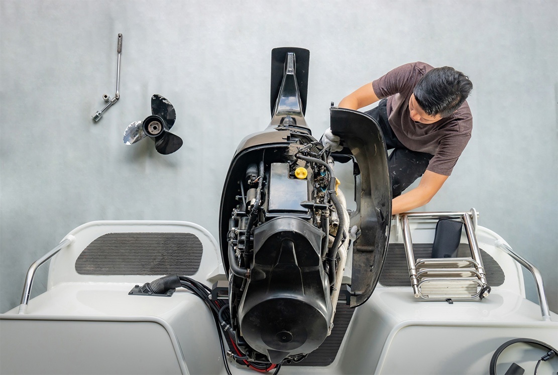 Homme faisant une réparation d'un moteur à bateau